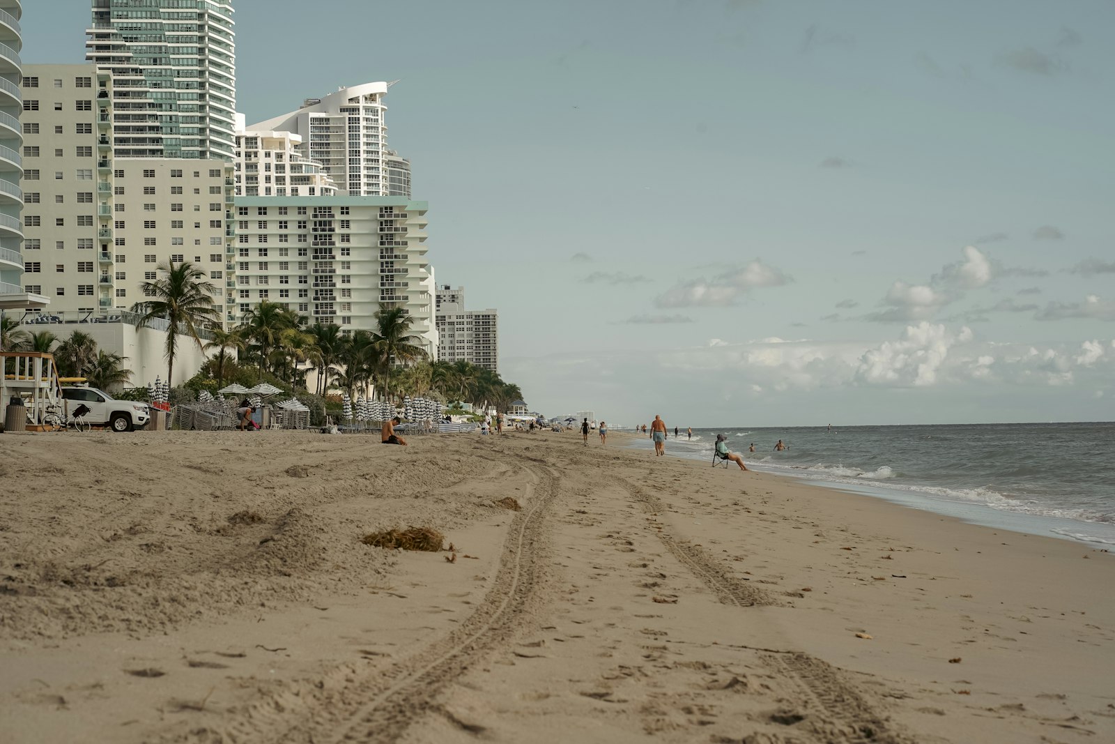 a beach with people and buildings in the background